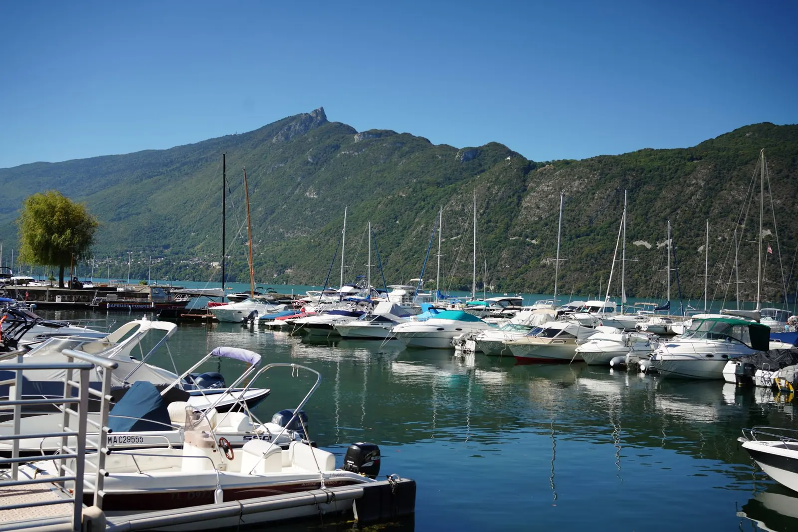 Port de plaisance d'Aix-les-Bains : bateaux à moteur et voiliers amarrés devant la montagne