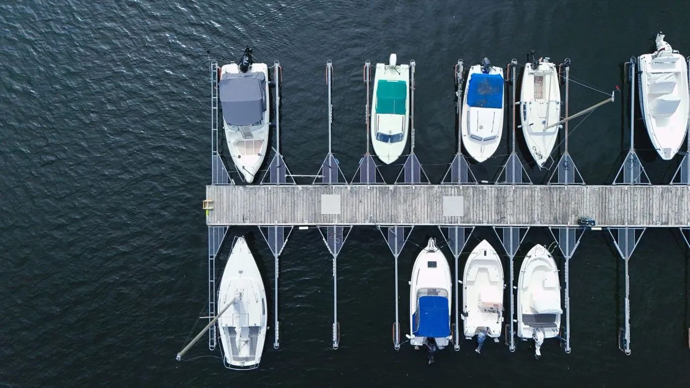 Bateaux à moteur amarrés de part et d'autre d'un ponton, vue aérienne