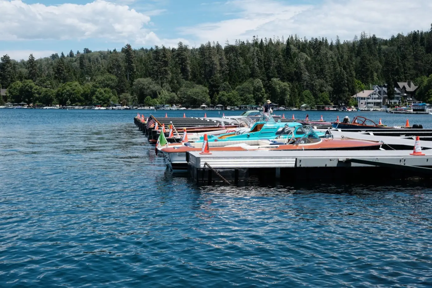 Bateaux en bois d'époque amarrés à un ponton sur un lac bordé de forêt