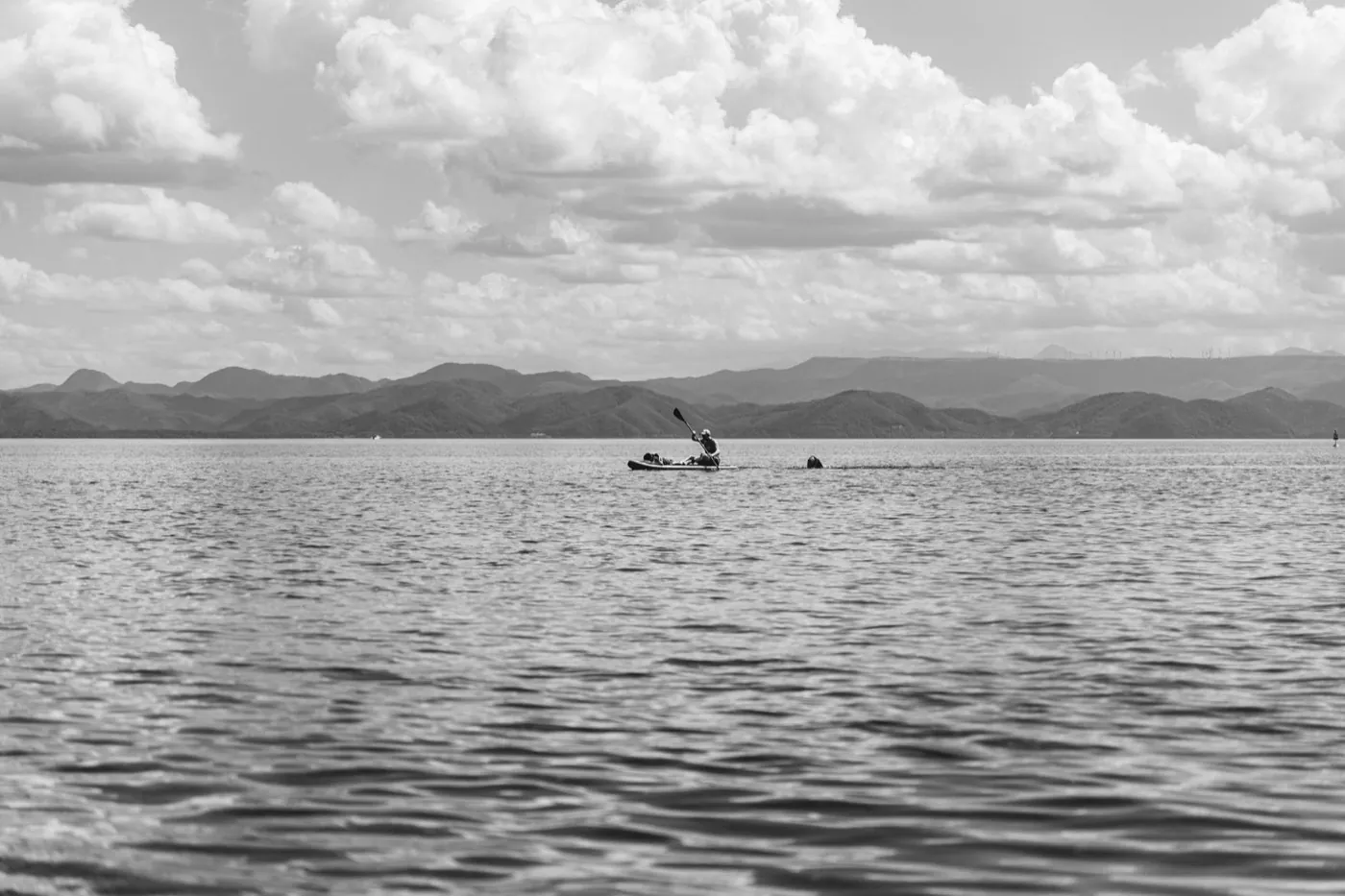 Pagayeur en kayak sur un grand lac, photo en noir et blanc